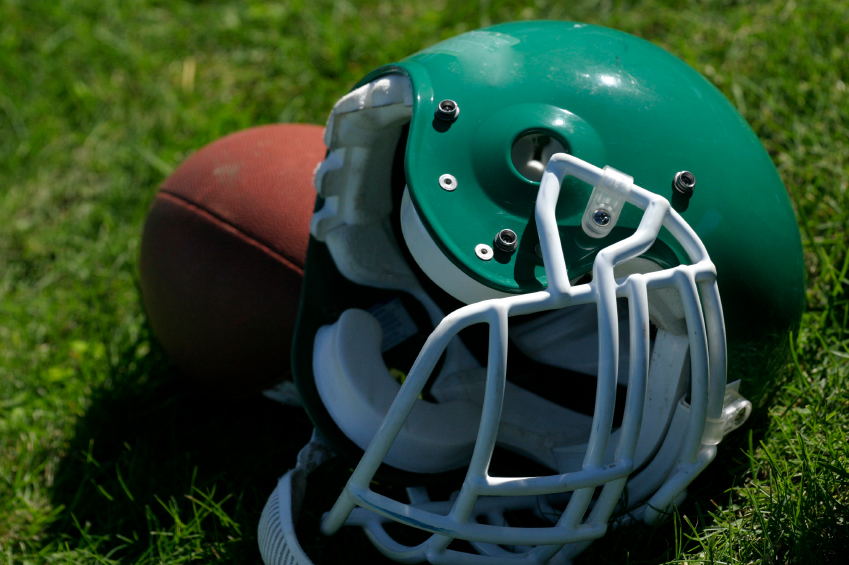 Close-up of a green football helmet on grass