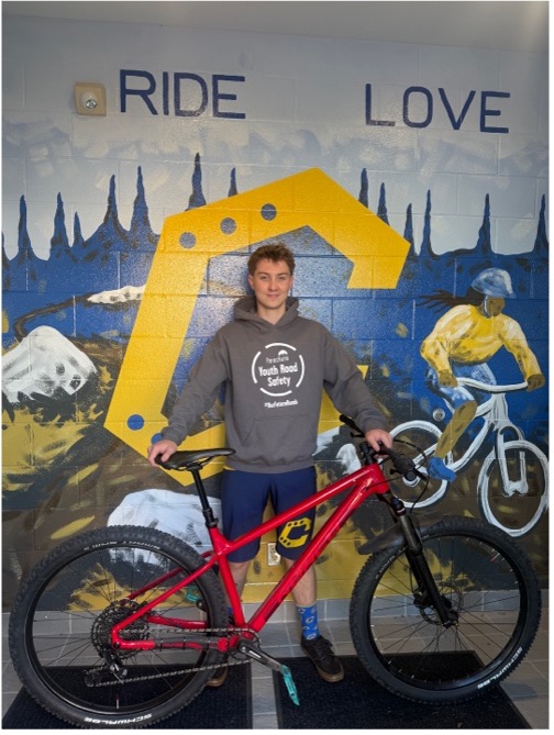 Photo of Alexander Depew holding a bicycle
