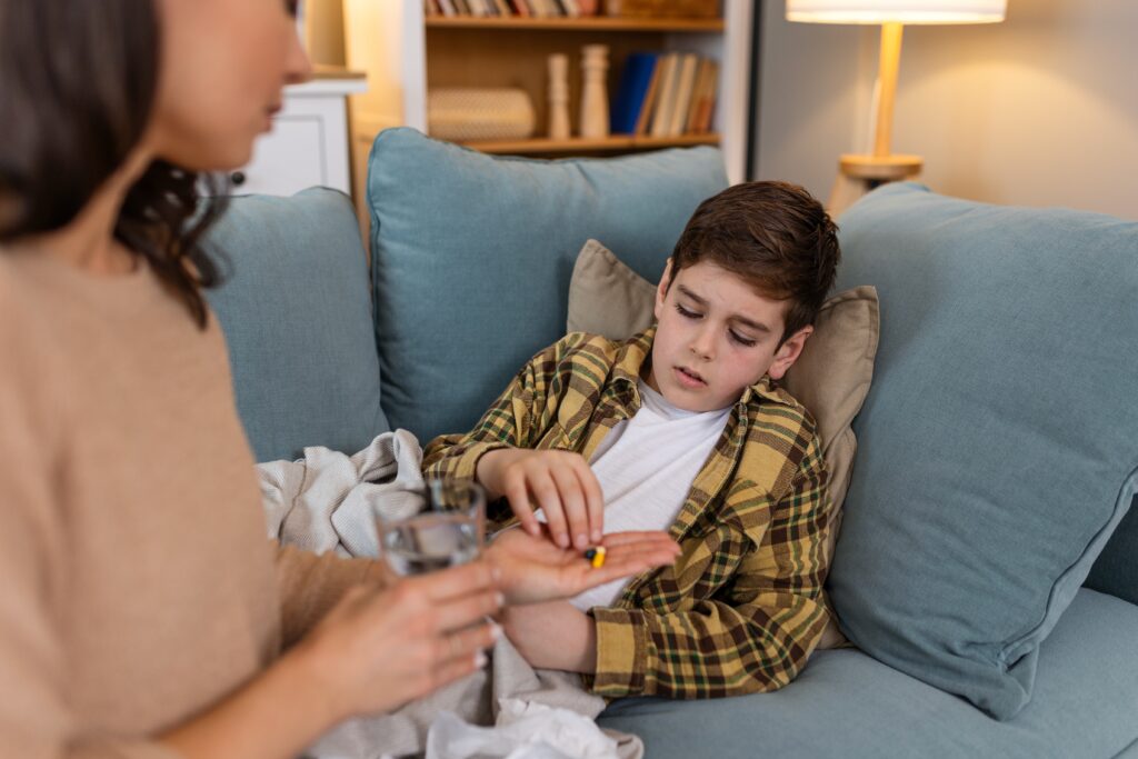 Sick boy taking medicine tablet