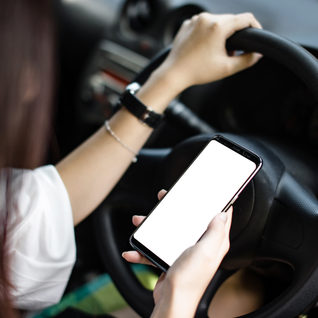 Woman driving while looking at her phone.
